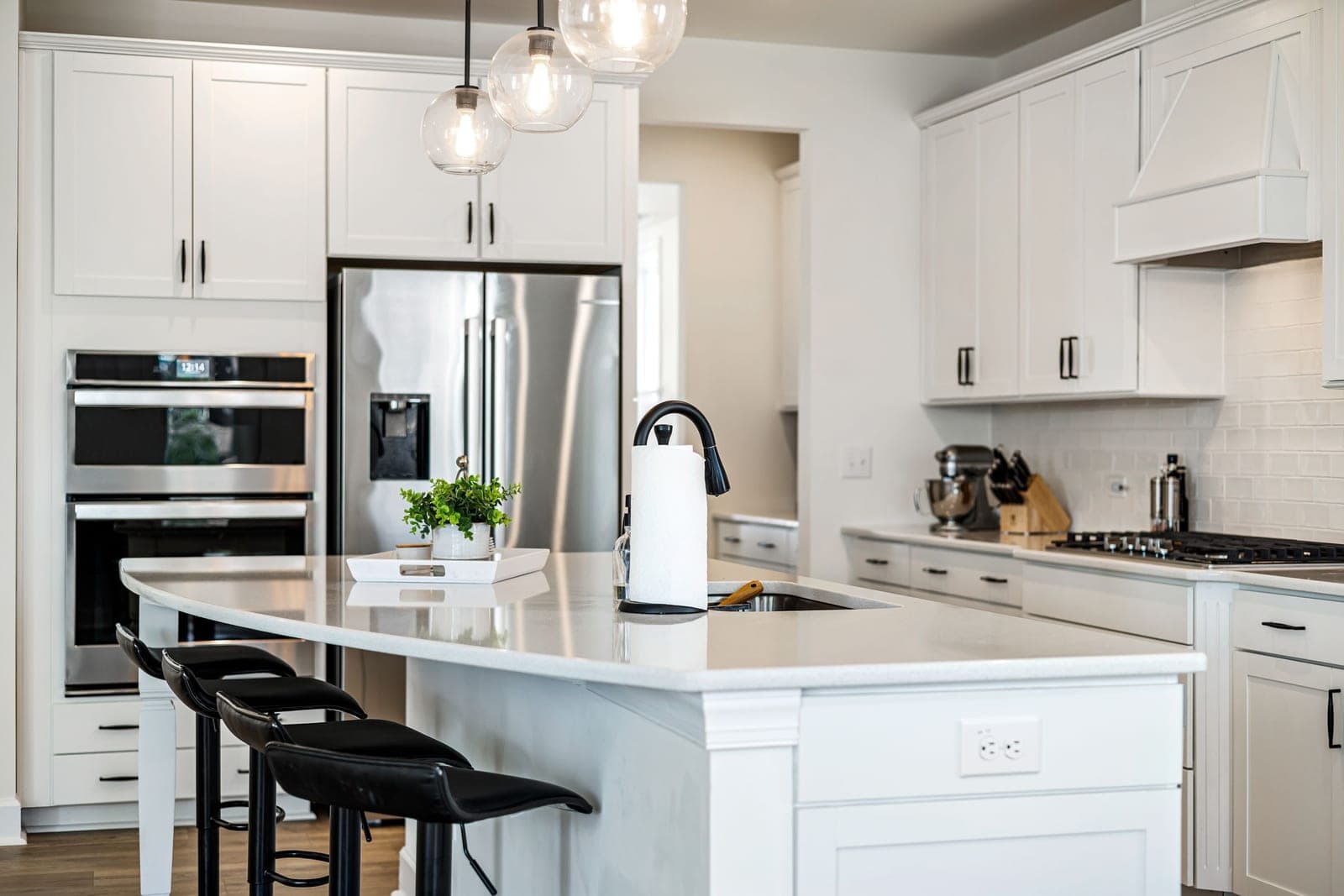 Reference photo of a clean white kitchen with an island and pendant lights